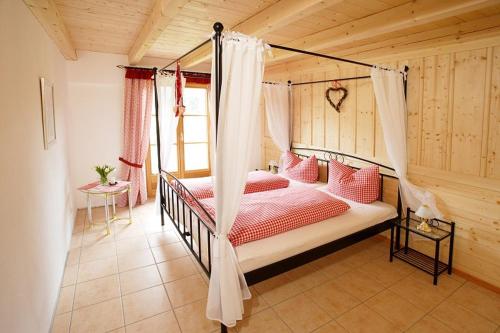 施万高Jägerhof und Jägerstadel的一间卧室配有一张带红色枕头的天蓬床
