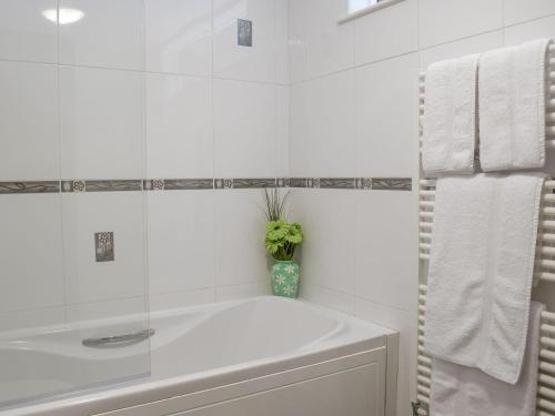 Gelliwen埃尔姆迎宾小屋的白色的浴室设有浴缸和水槽。