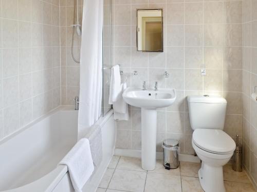 KelsallWeetwood Lodge的浴室配有卫生间、盥洗盆和浴缸。