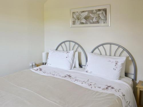 KelsallWeetwood Lodge的一张白色的床,上面有两个白色的枕头