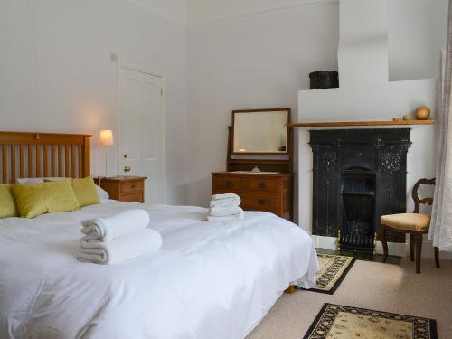 亨斯坦顿女主人之家度假屋的卧室配有白色床和毛巾