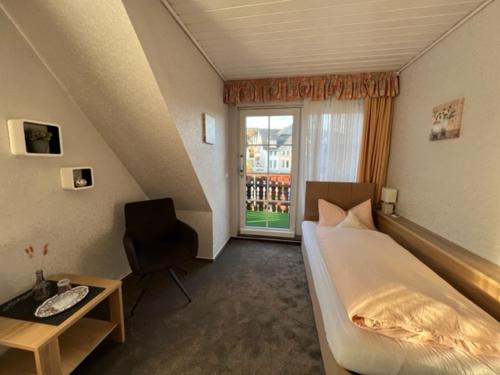 维林根Sevda's Hotel Garni Weinforth的一间卧室配有一张床、一张书桌和一个窗户。