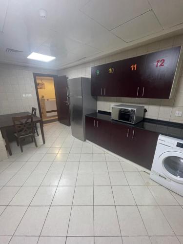 迪拜Pharaohs Inn Deira Hostel的客房内的厨房配有洗衣机