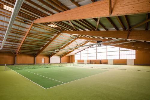 比肯Thöles Hotel Bücken的一座带窗户的大型建筑中的网球场