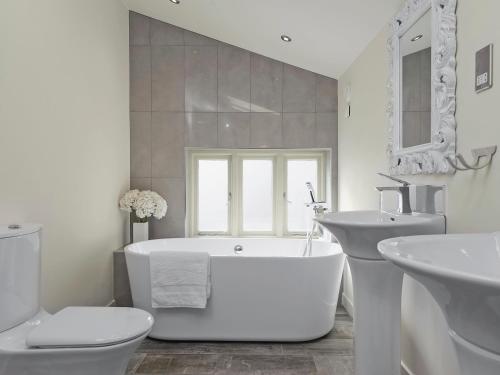 BradwellTatters Barn的白色的浴室设有浴缸和水槽。