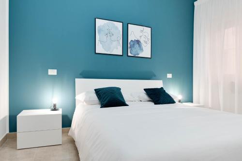 克罗托内Jòia Holiday Home的蓝色的卧室设有一张白色大床和蓝色的墙壁