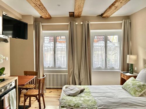 MasevauxHostellerie Alsacienne的卧室配有一张床、一张书桌和窗户。