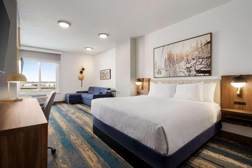 帕克La Quinta Inn & Suites by Wyndham Denver Parker的酒店客房设有一张大床和一张沙发。
