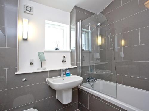 卡比斯贝Una Argentum 61的浴室配有盥洗盆、卫生间和浴缸。