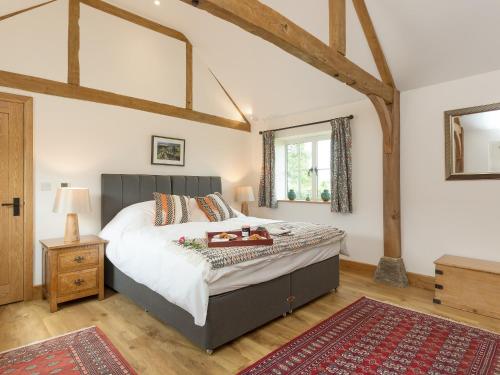 皇家伍顿巴西特The Calf Shed-ukc2113的一间卧室设有一张大床,铺有木地板