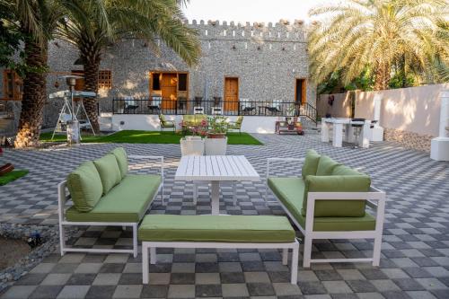 尼兹瓦Aryaf hostel的庭院配有两把椅子和一张桌子