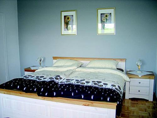 奥斯措兹Wiesenhof的卧室配有一张床,墙上挂有两张照片