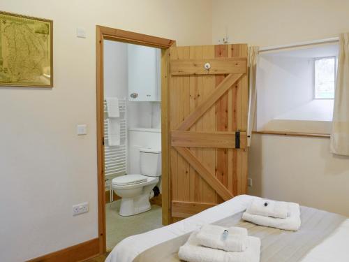 北威灵厄姆老奶牛场乡村别墅的一间带卫生间的浴室和一张带毛巾的床