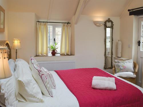 StokenhamMeadow Mews的一间卧室配有一张带红色毯子的大床