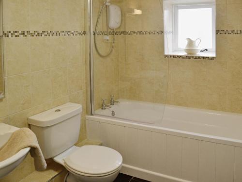 StokenhamMeadow Mews的浴室配有卫生间、浴缸和水槽。