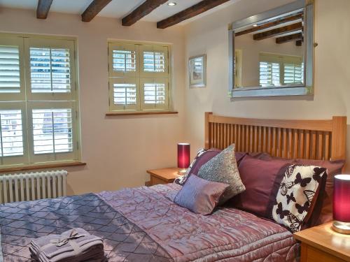 斯陶尔波特The Hayloft的卧室配有床、镜子和窗户。