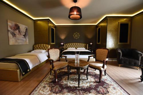 波格拉德茨Hotel Hymeti's Palace的一间卧室配有两张床和一张桌子及椅子