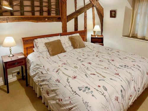 Brompton Ralph奥德维尔乡村别墅的一间卧室配有一张大床和木制床头板