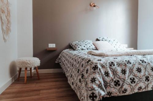 布鲁瓦Le petit rempart - Appt lumineux 2pers au coeur de Blois的一间卧室配有一张带被子和凳子的床