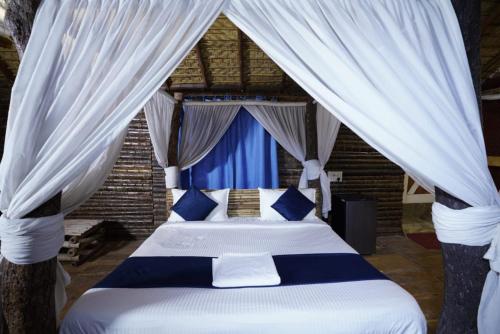 海得拉巴Farm Stay Resort - Shamirpet, Hyderabad的一间卧室配有蓝色和白色窗帘的床