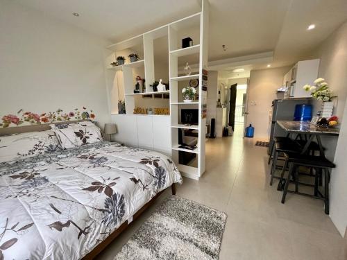达沃市Elaiza's Cozy Home - Matina Enclaves Building C Unit 815的一间带一张床和一张书桌的卧室和一间厨房