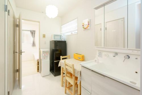 大阪Osaka - House - Vacation STAY 8351的厨房配有桌子和黑冰箱。