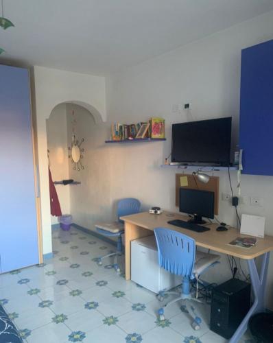 伊斯基亚La Stanza sul Porto的办公室,配有一张桌子、一台电脑和两把椅子