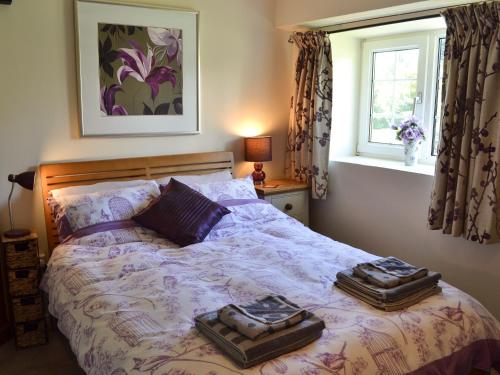 利扎尔德Skyber Cottage的一间卧室配有一张床,上面放着两个托盘