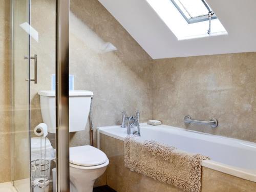 Mealsgate怀特豪尔乡村别墅的一间带卫生间和浴缸的浴室