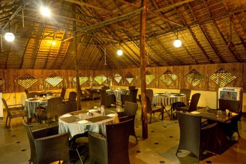 海得拉巴Farm Stay Resort - Shamirpet, Hyderabad的一间在房间内配有桌椅的餐厅