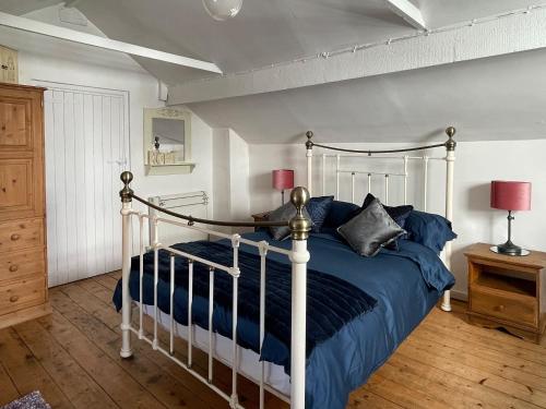 绍斯波特斯坦利乡村别墅的一间卧室配有一张带蓝色床单和枕头的床。