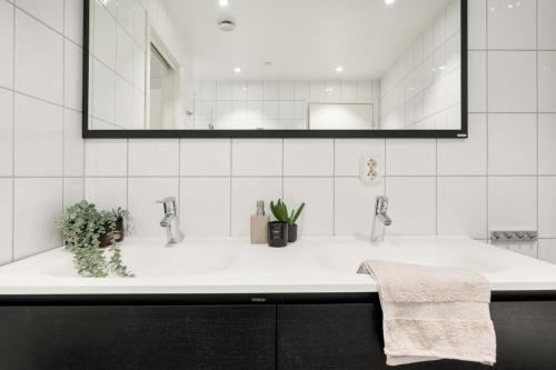 卑尔根Fløyen Lux Apartment的白色的浴室设有水槽和镜子