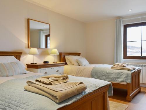 PaibleCreagan Na Mara的一间卧室配有两张床和镜子