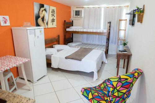 布希奥斯Flats vila bela Búzios的小房间设有两张床和一台冰箱