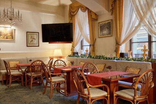 布拉格FLEUR DE LIS HOTEL的一间带桌椅和电视的餐厅