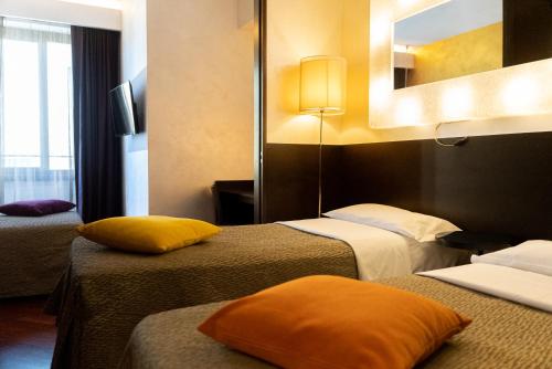 罗马迪罗马瑞丽酒店的酒店客房,设有两张床和镜子