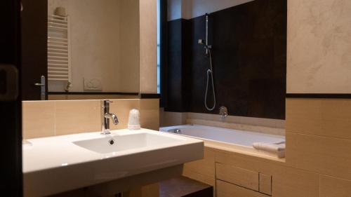 罗马迪罗马瑞丽酒店的浴室配有盥洗盆和浴缸。