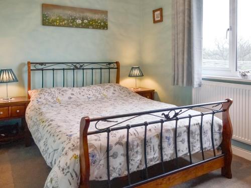 Caeathro依多尔乡村别墅的一间卧室配有一张床、两盏灯和一个窗户。