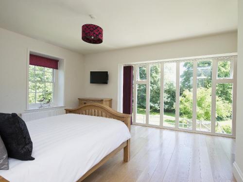 萨顿布里奇Curlew Barn的卧室设有白色的床和大窗户