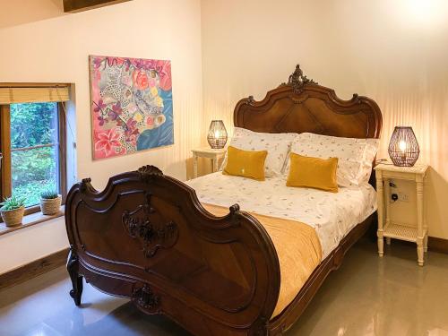 Darenth蓝贝儿度假屋的一间卧室配有一张带黄色枕头的大型木制床。