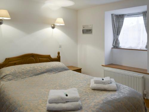 北威灵厄姆布赖德尔斯乡村别墅 的一间卧室配有一张床,上面有两条毛巾