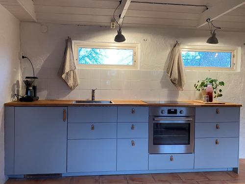 锡姆里斯港BRICK Österlen的厨房配有白色橱柜、水槽和炉灶。