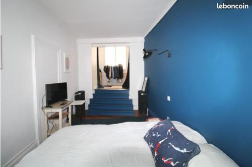 迪耶普Chez Samuel à Dieppe的一间卧室设有一张带蓝色墙壁和楼梯的床。