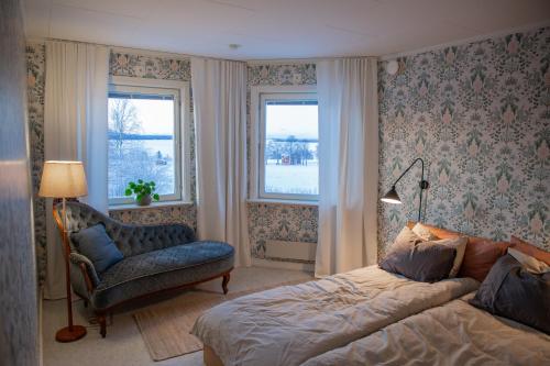 OrrvikenCozy mountain view apartment的一间卧室配有一张床、一把椅子和窗户。