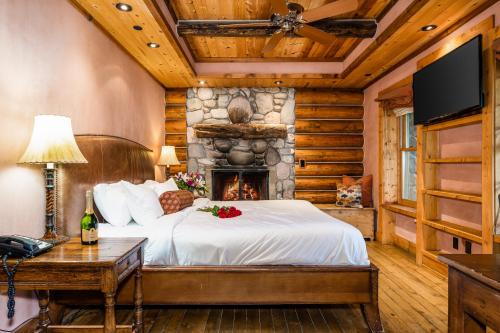 大天空峡谷村彩虹牧场旅馆的一间卧室配有一张床和一个壁炉