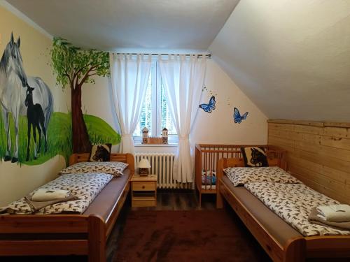 MalenoviceJízdárna Malenovice的墙上挂着一幅树壁画的房间里,有两张床