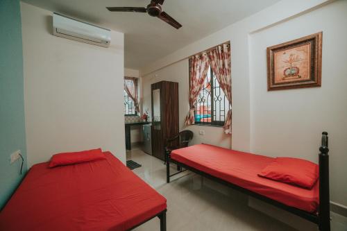 尼禄Casa de Fernandes的红色床单的客房内的两张床