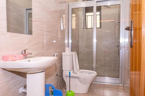 布琼布拉Cheerful 4-bedroom home with parking的浴室配有卫生间、盥洗盆和淋浴。