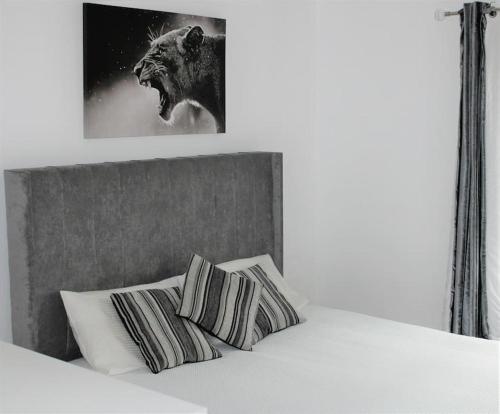 LexdenLuxury Apartment Close to Town Centre的一张带两个枕头的床和一幅狮子的照片