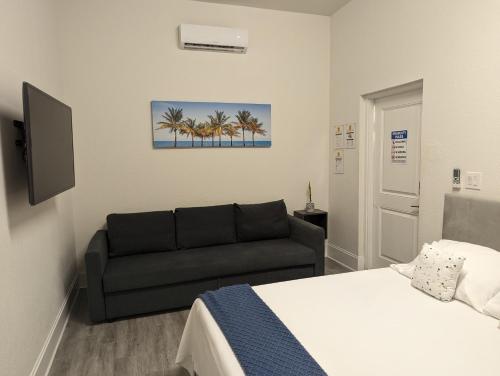 迈阿密Cozy Private Room的一间卧室配有一张床和一张沙发